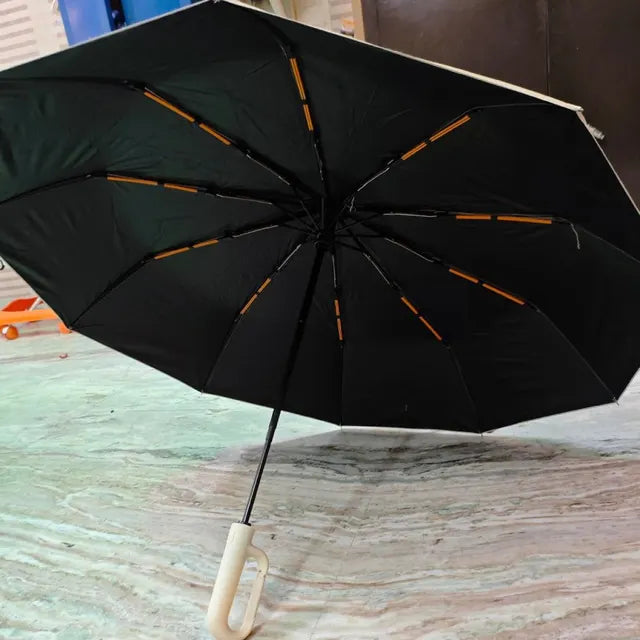 Umbremo umbrella open indoors, beige hook handle, photographed on a phone